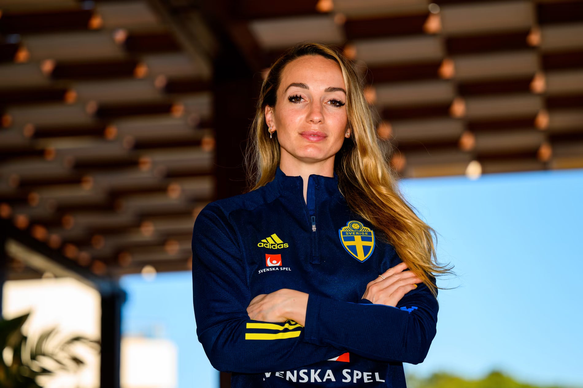 Kosovare Asllani wearing a Sweden women’s national team half‑zip jacket featuring Adidas logo and SvFF badge — a Bornaballer BAB™ lifestyle inspiration image honoring successful Swedish women’s national team legend Kosovare Asllani, leadership, resilience, and the premium sustainable football‑and‑fashion mindset inspired by Swedish legends.
